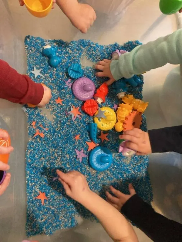 A sensory bin with small hands exploring